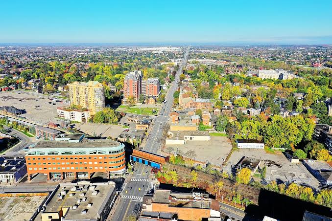 Overhead cityscape with tree-lined avenue and railway bridge