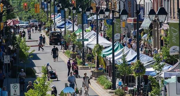 Busy downtown street fair with tents and pedestrians