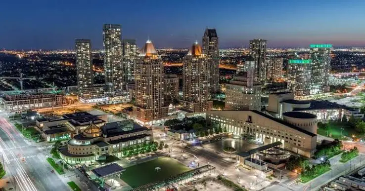 Downtown city skyline at dusk with illuminated skyscrapers